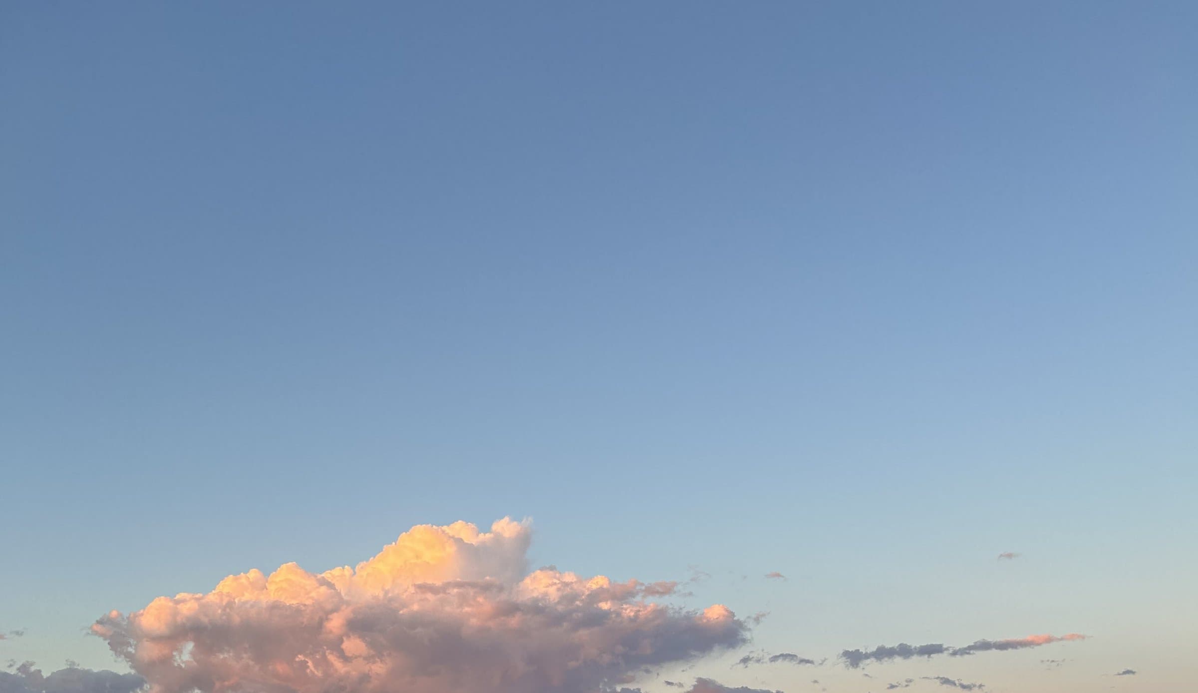 Sunlit pink clouds in a blue sky